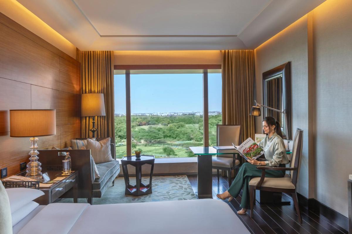 a woman sitting in a chair in a hotel room at The Leela Ambience Gurugram Hotel & Residences - The Luxury Urban Sanctuary in Gurgaon