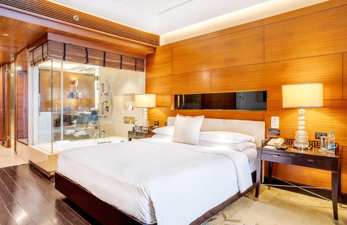 a bedroom with a large bed and a bathroom at The Leela Ambience Gurugram Hotel & Residences - The Luxury Urban Sanctuary in Gurgaon