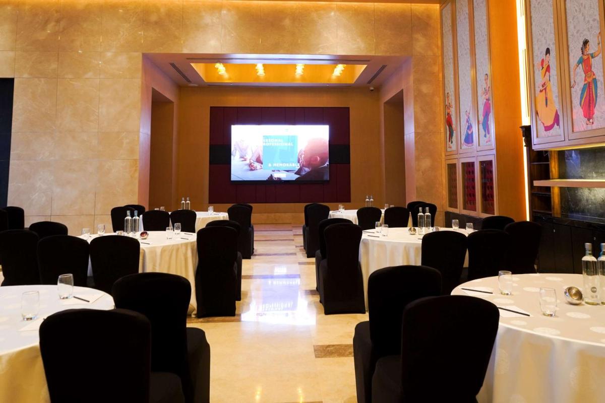 a conference room with tables and chairs and a screen at Radisson Blu Hotel Amritsar in Amritsar