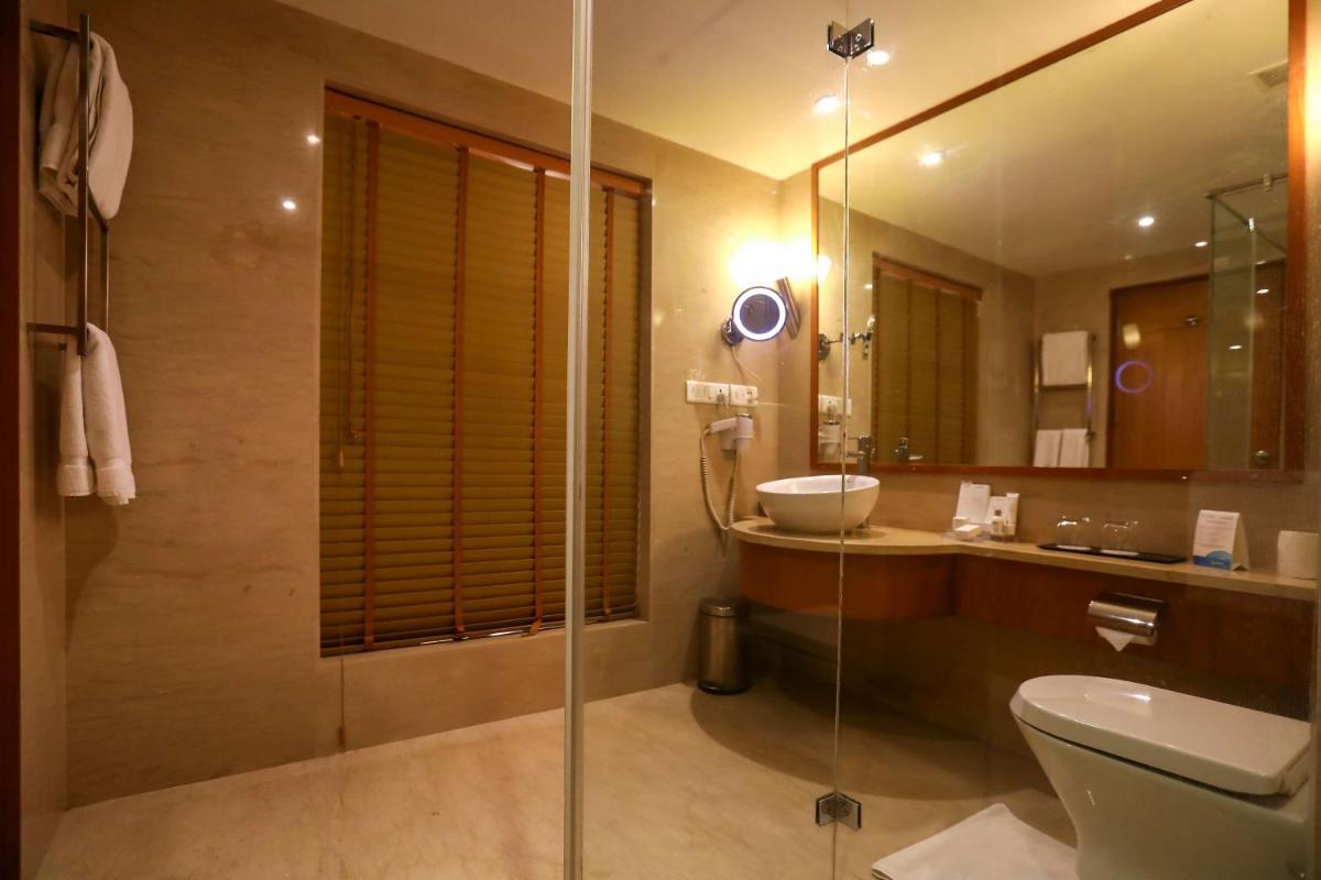 a bathroom with a shower and a toilet and a sink at Radisson Blu Hotel Chennai City Centre in Chennai a bathroom with a shower and a toilet and a sink at Radisson Blu Hotel Chennai City Centre in Chennai