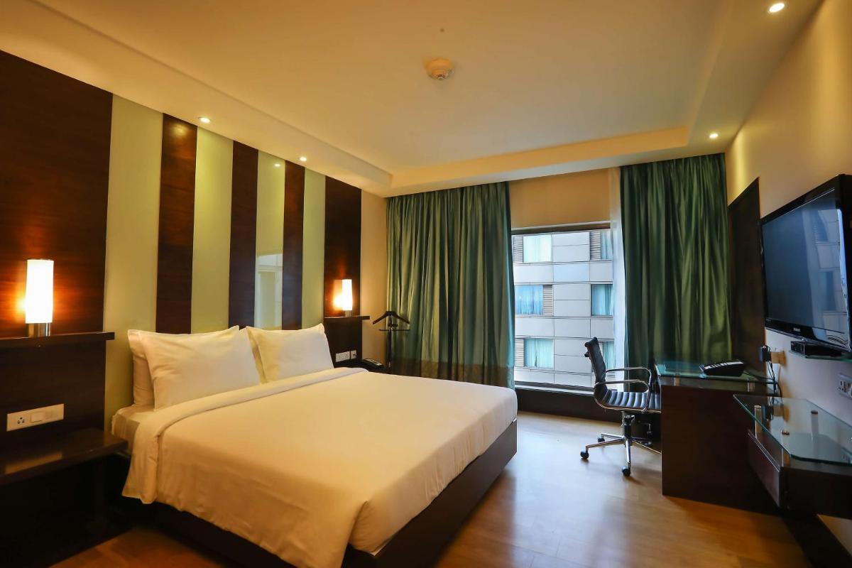 a hotel room with a bed and a television at Radisson Blu Hotel Chennai City Centre in Chennai a hotel room with a bed and a television at Radisson Blu Hotel Chennai City Centre in Chennai