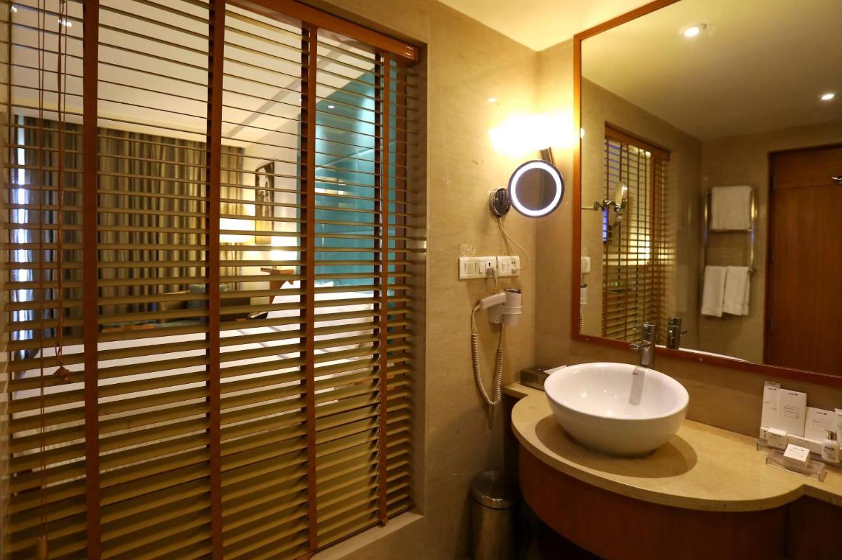 a bathroom with a sink and a mirror at Radisson Blu Hotel Chennai City Centre in Chennai a bathroom with a sink and a mirror at Radisson Blu Hotel Chennai City Centre in Chennai