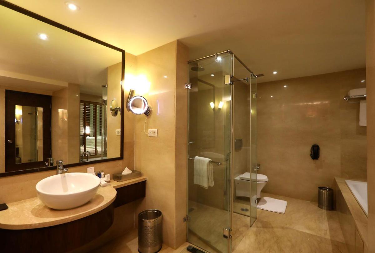 a bathroom with a sink and a glass shower at Radisson Blu Hotel Chennai City Centre in Chennai a bathroom with a sink and a glass shower at Radisson Blu Hotel Chennai City Centre in Chennai
