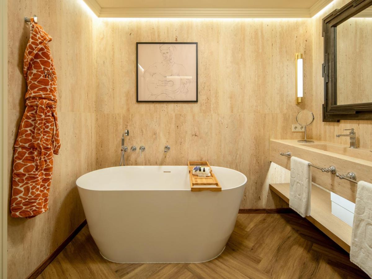 Un baño con una bañera grande y un lavabo. en Only YOU Hotel Sevilla, en Sevilla