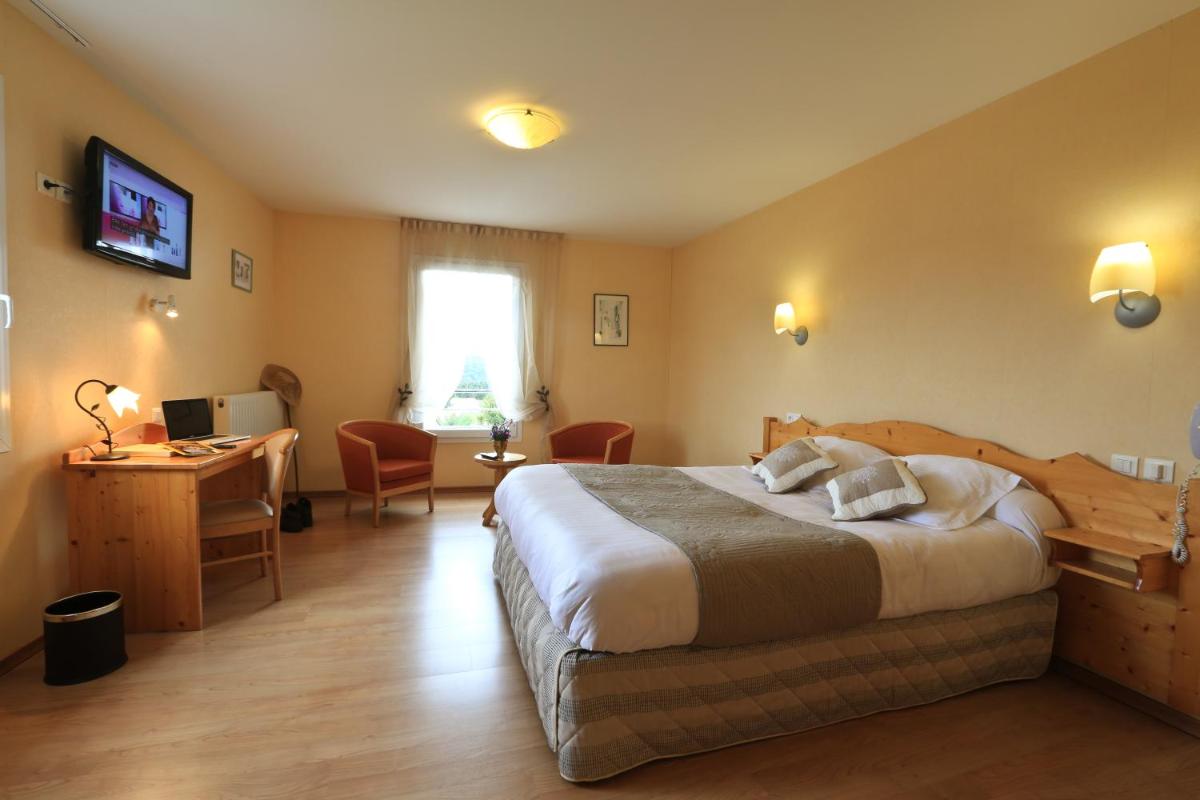 une chambre d'hôtel avec un lit, un bureau et un ordinateur dans l'établissement Logis Hotel Spa Restaurant Le Provence, à Lanarce