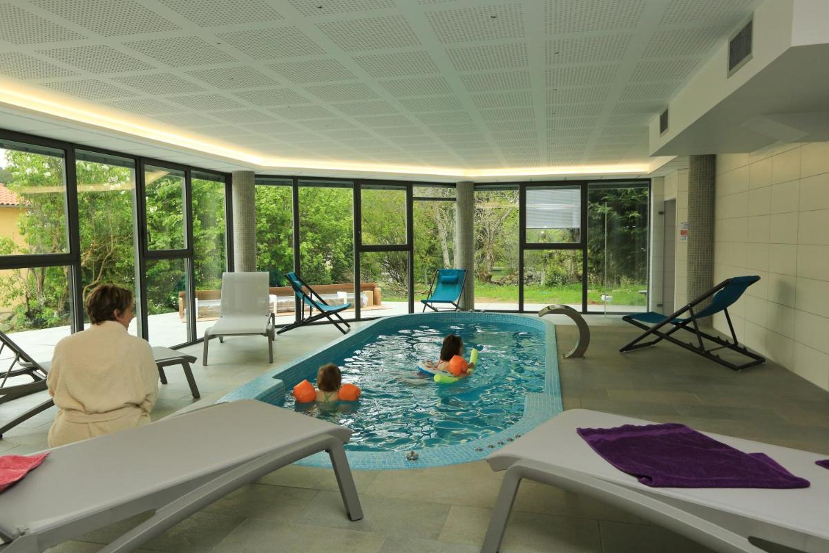 2 enfants dans une piscine dans une chambre avec fenêtres dans l'établissement Logis Hotel Spa Restaurant Le Provence, à Lanarce