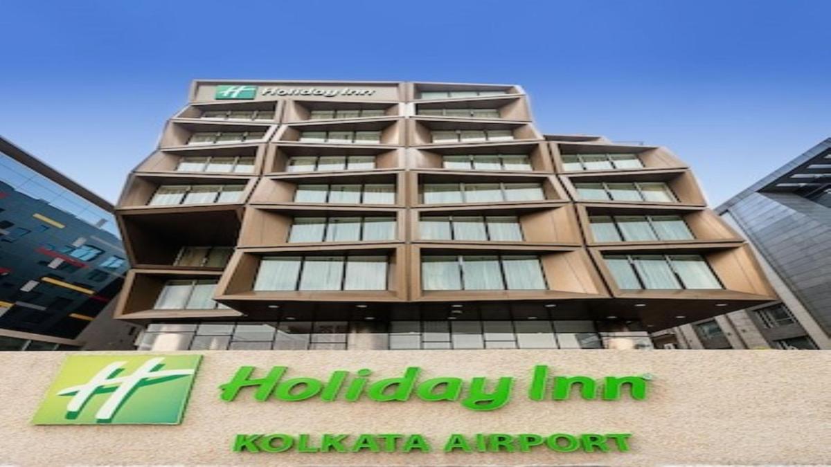 a tall building with a sign in front of it at Holiday Inn Kolkata Airport by IHG in Kolkata