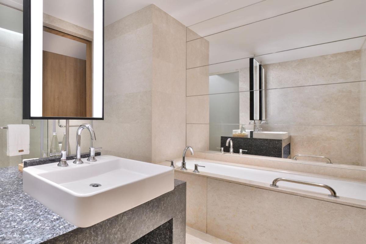 a bathroom with a white sink and a tub at The Westin Mumbai Powai Lake in Mumbai