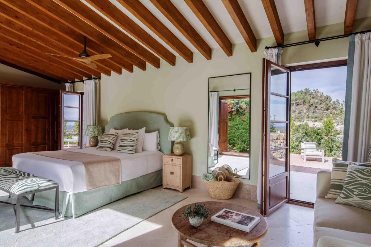 Un dormitorio con una cama y una sala de estar. en Son Bunyola Resort and Villas, en Banyalbufar