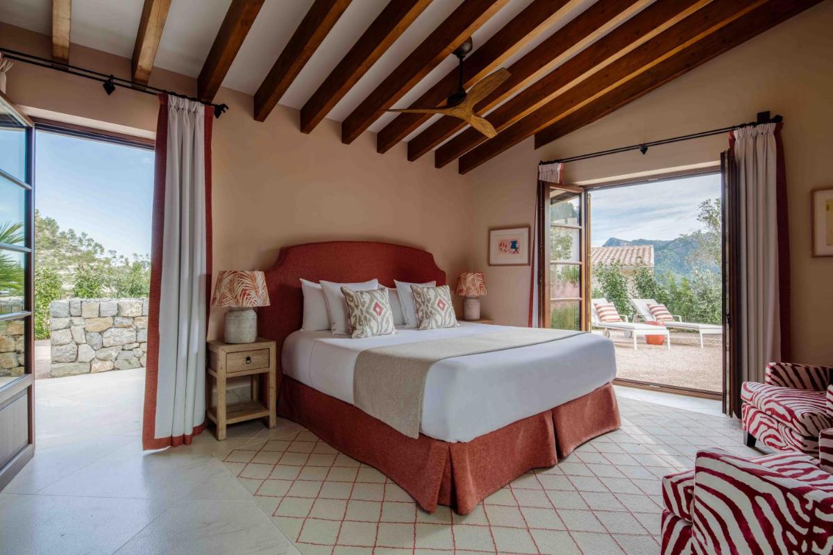 Un dormitorio con una cama y una ventana grande. en Son Bunyola Resort and Villas, en Banyalbufar