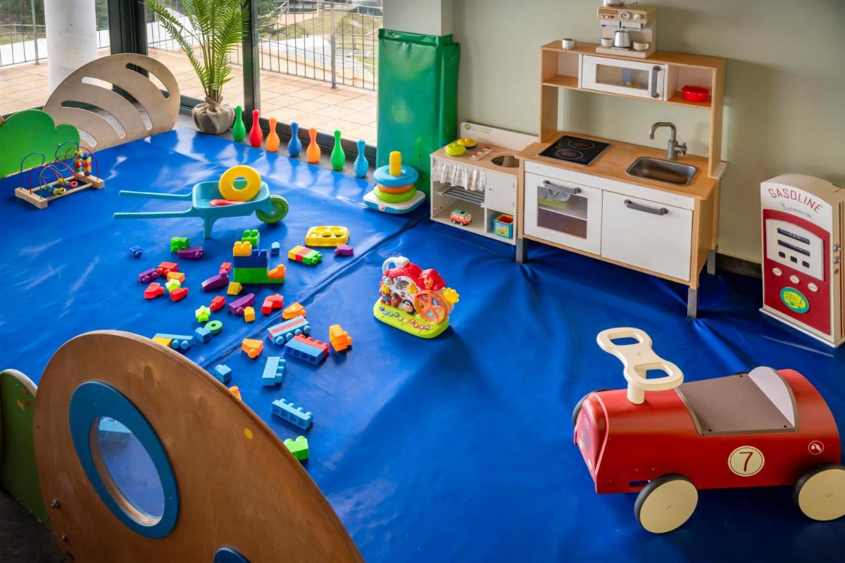 una sala de juegos para niños con juguetes en el suelo en Vilar Rural De Sant Hilari Sacalm by Serhs Hotels, en Sant Hilari Sacalm