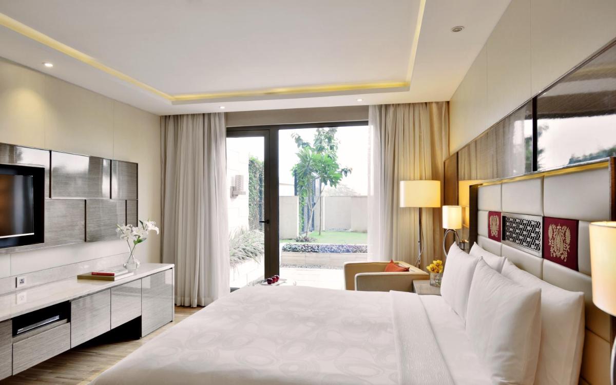 a bedroom with a large bed and a television at JW Marriott Mumbai Sahar Airport in Mumbai a bedroom with a large bed and a television at JW Marriott Mumbai Sahar Airport in Mumbai