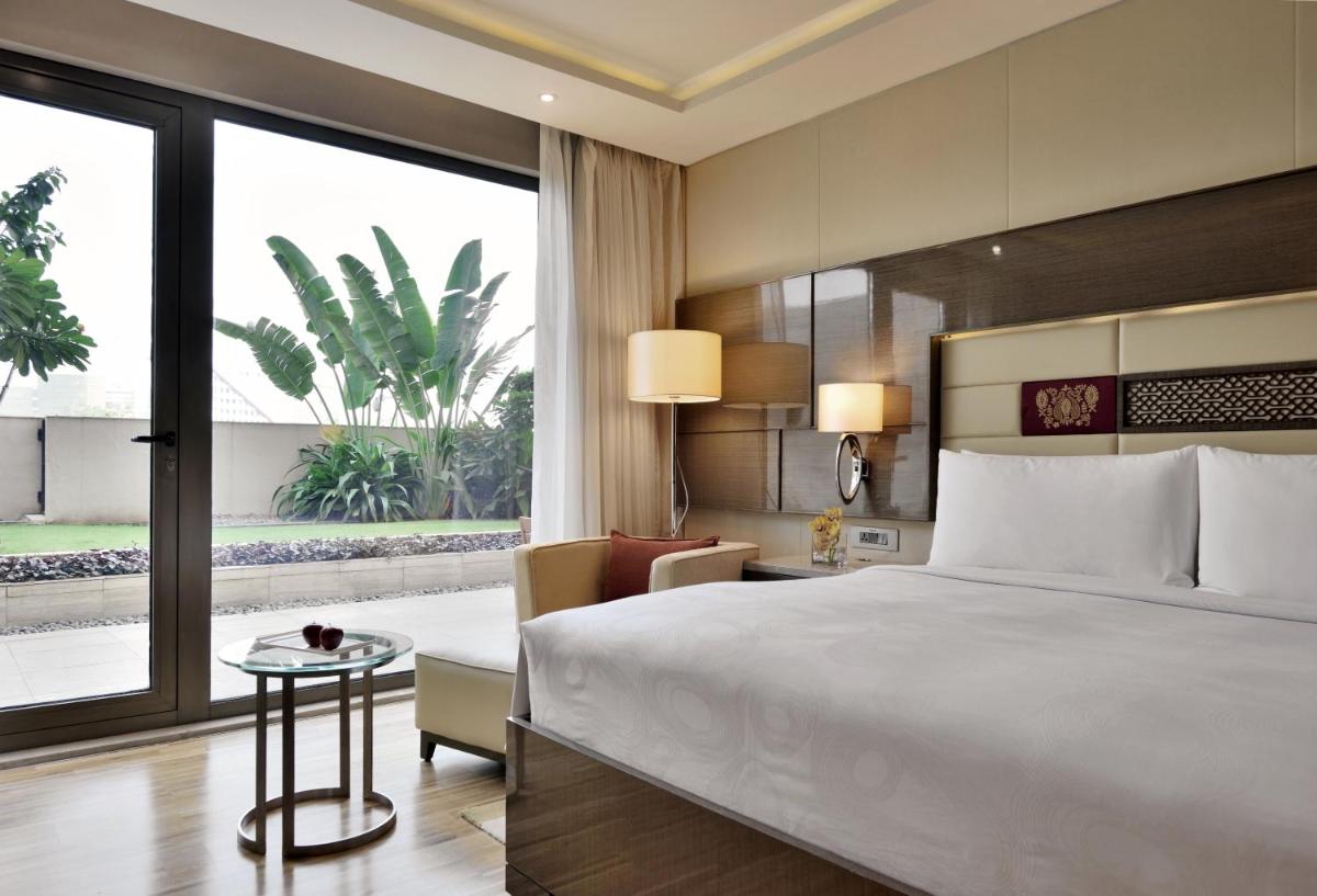 a bedroom with a large bed and a large window at JW Marriott Mumbai Sahar Airport in Mumbai