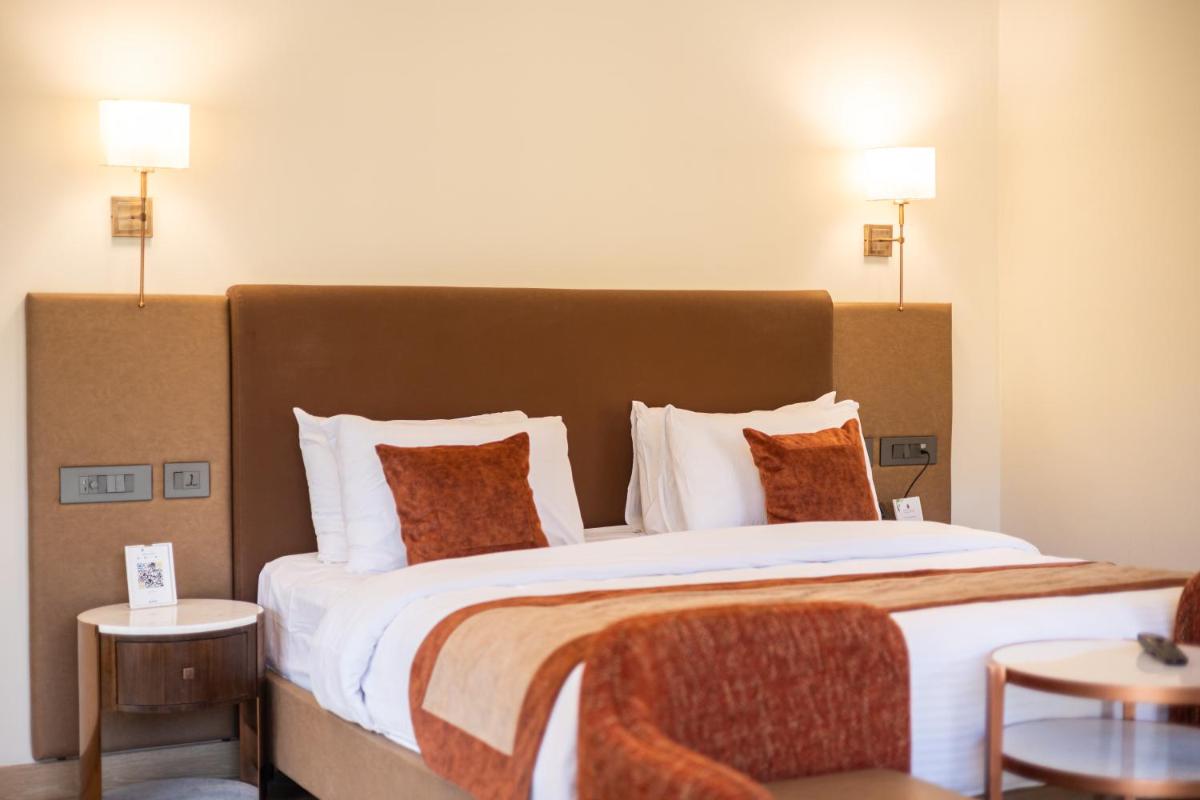 a large bed in a hotel room with two lamps at Antalya By Divine Ganga Cottage in Rishīkesh