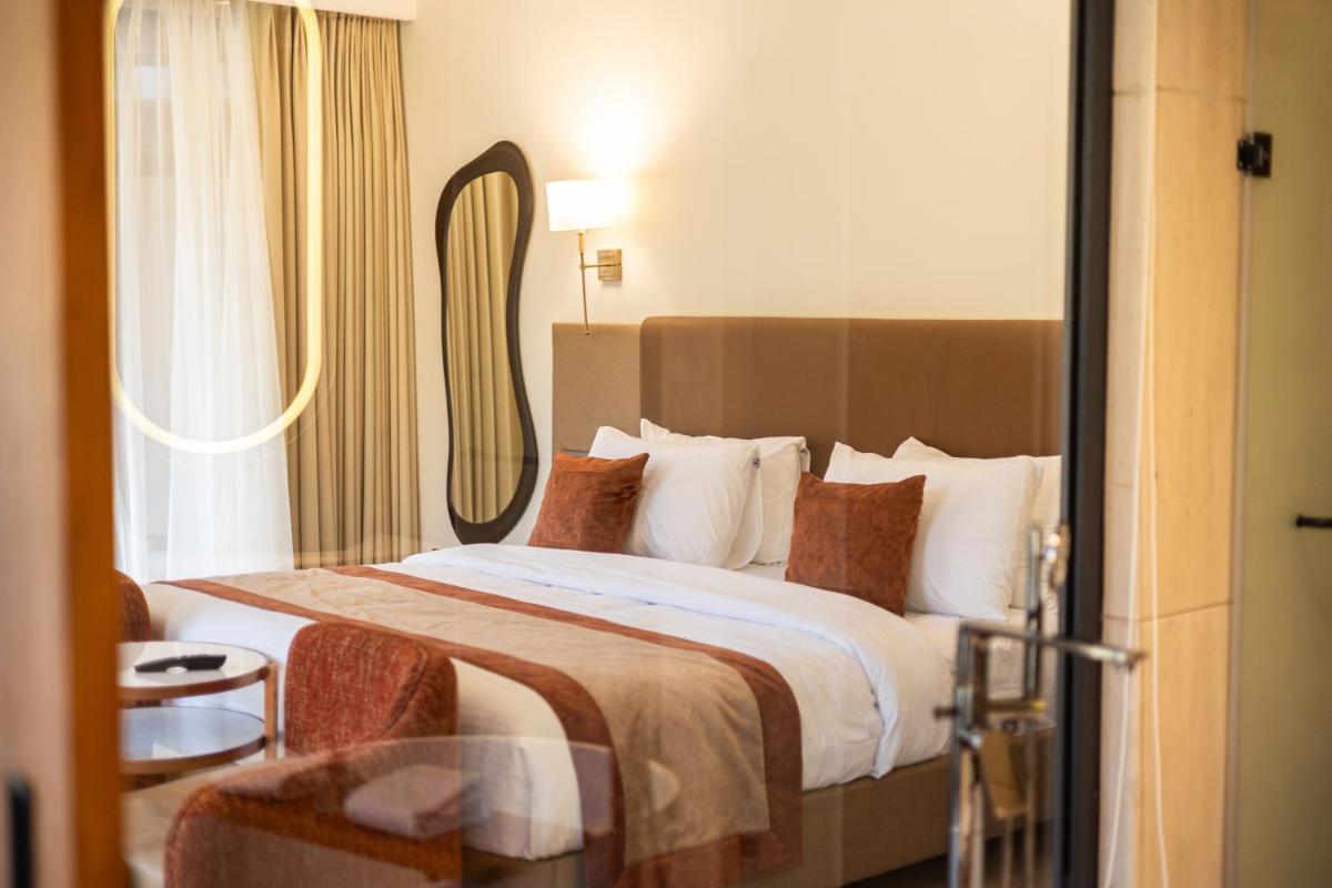a hotel room with a large bed with a window at Antalya By Divine Ganga Cottage in Rishīkesh