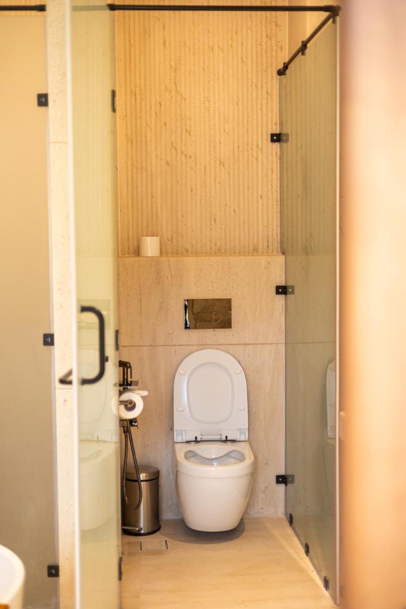 a small bathroom with a toilet in a stall at Antalya By Divine Ganga Cottage in Rishīkesh