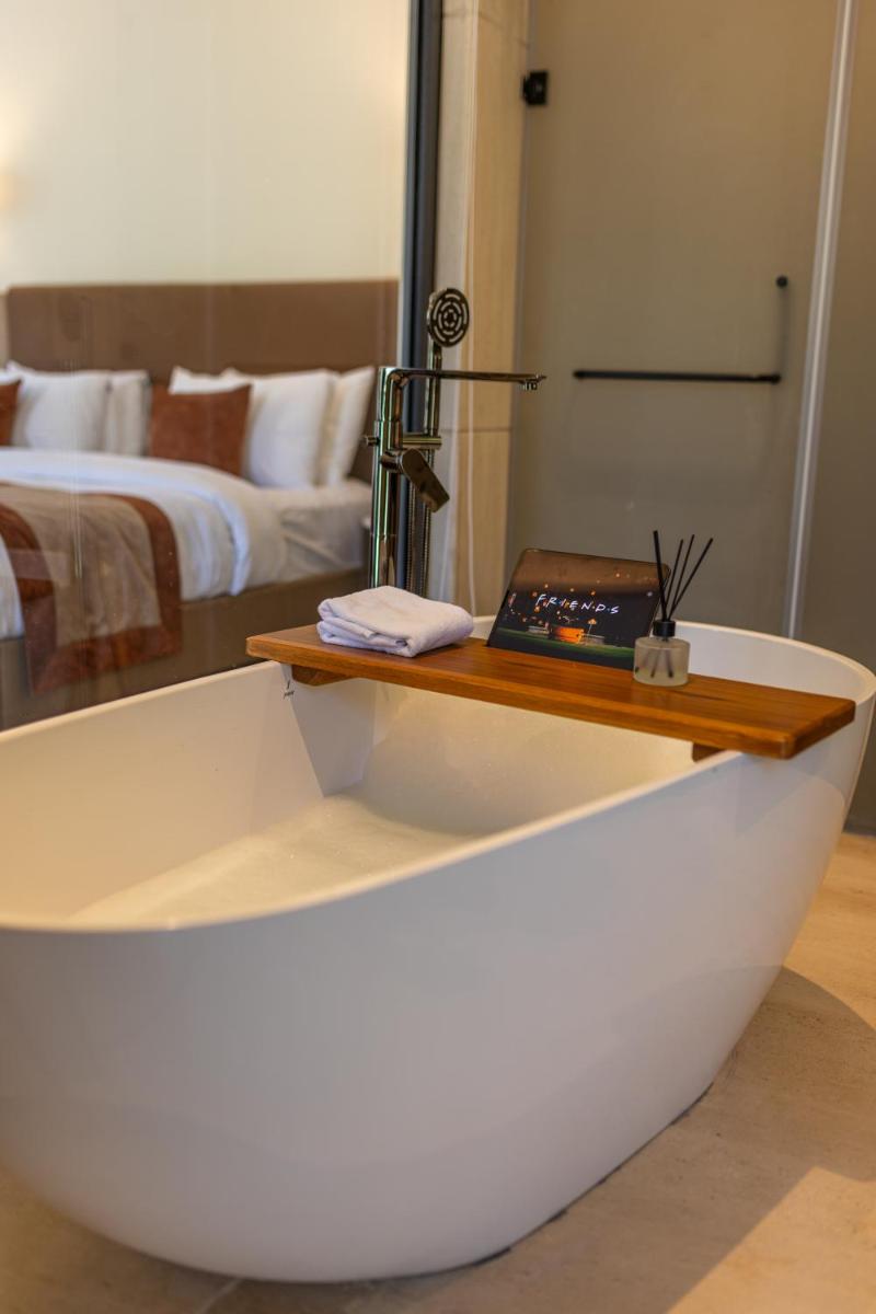 a bathtub with a table in front of a bedroom at Antalya By Divine Ganga Cottage in Rishīkesh