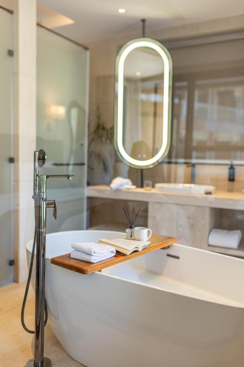 a bathroom with a bath tub and a mirror at Antalya By Divine Ganga Cottage in Rishīkesh