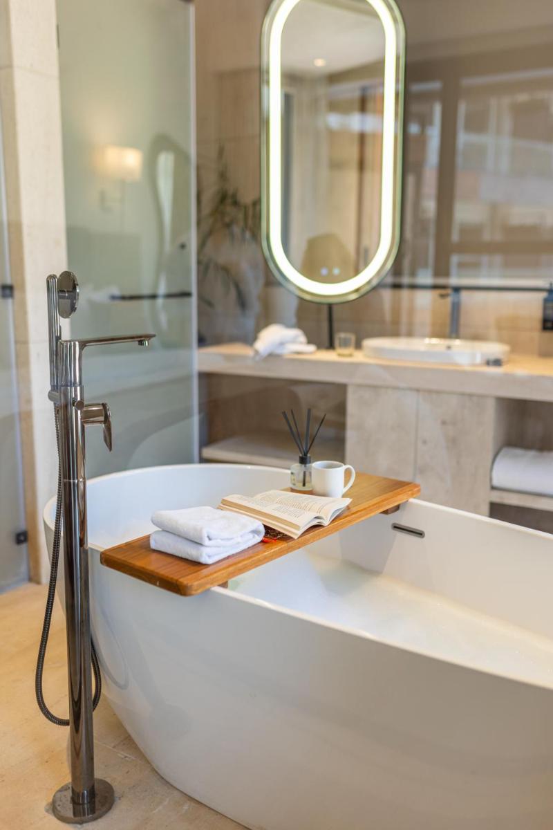 a bathroom with a bath tub and a mirror at Antalya By Divine Ganga Cottage in Rishīkesh