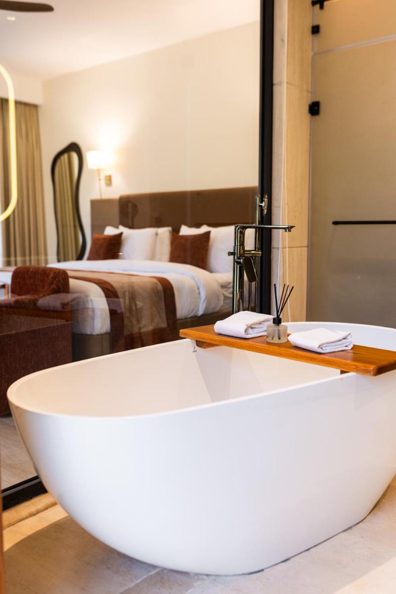 a bath tub in a room with two beds at Antalya By Divine Ganga Cottage in Rishīkesh