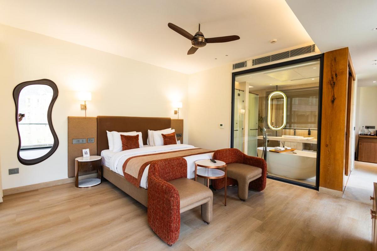 a bedroom with a bed and a bathroom with a tub at Antalya By Divine Ganga Cottage in Rishīkesh