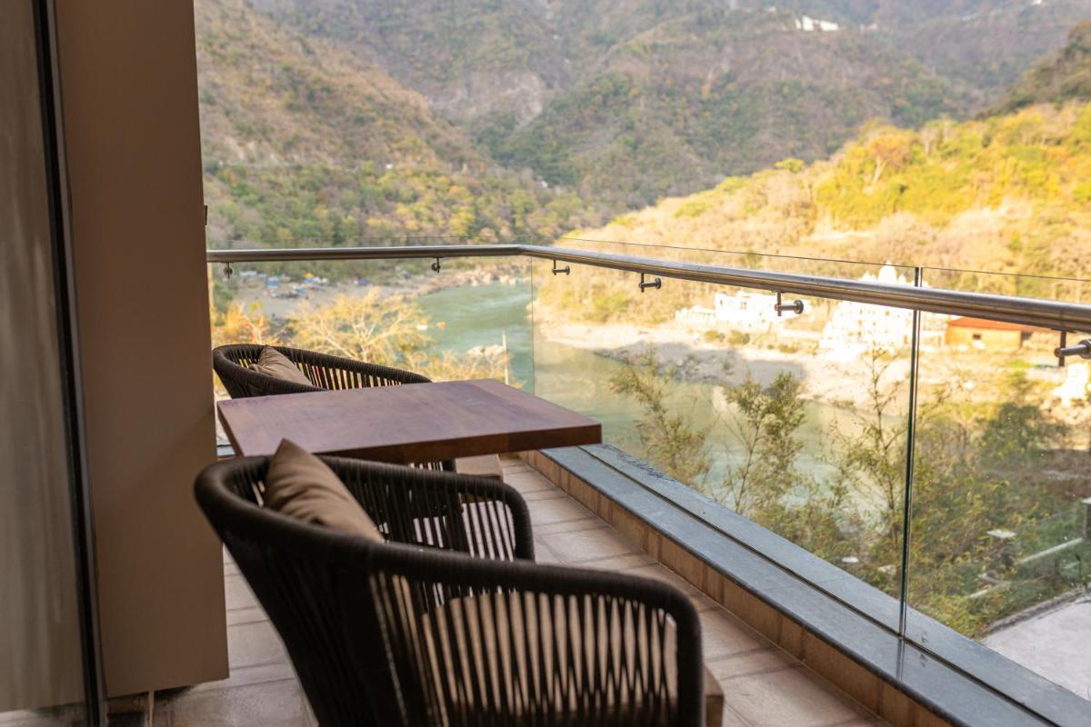 a balcony with two chairs and a table with a view at Antalya By Divine Ganga Cottage in Rishīkesh