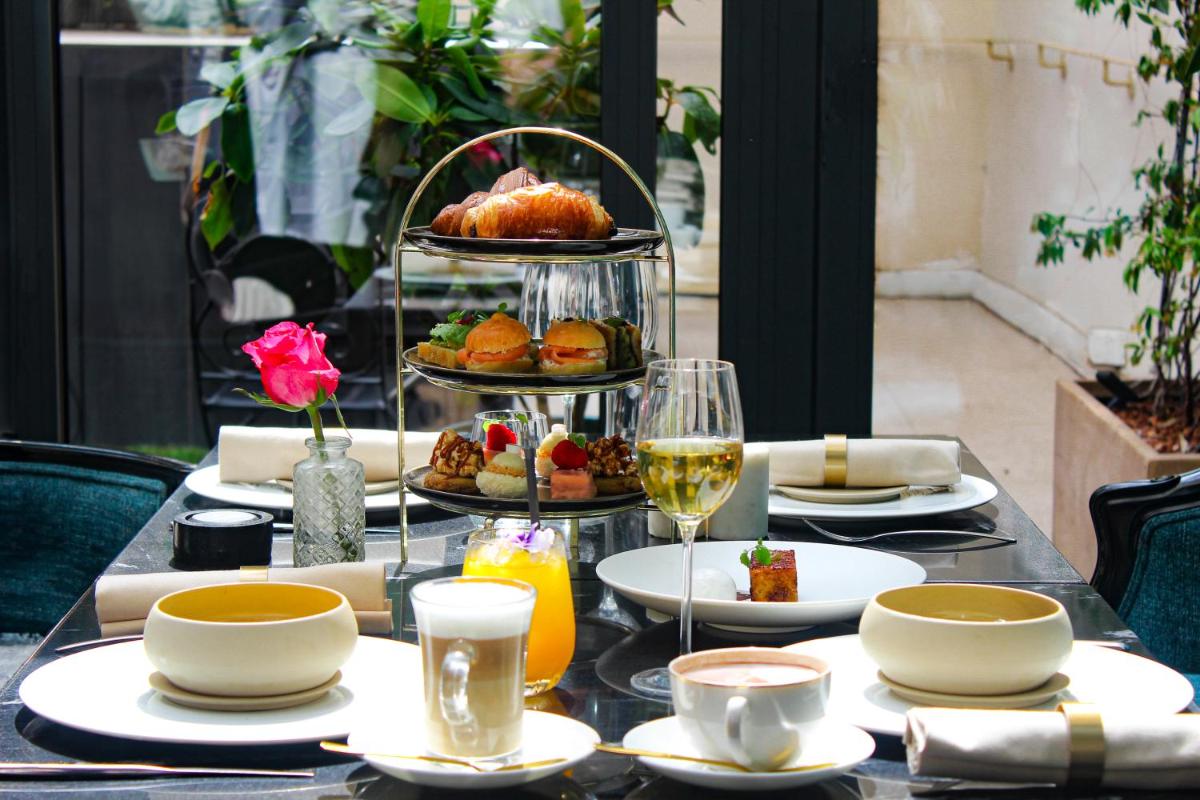 - une table avec un plateau de nourriture et une assiette de nourriture dans l'établissement Paris j'Adore Hotel & Spa, à Paris