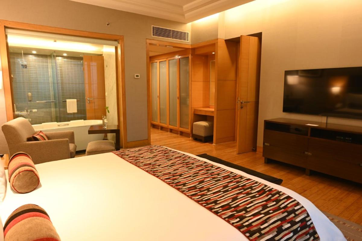 a hotel room with a bed and a flat screen tv at Crowne Plaza Today Gurugram by IHG in Gurgaon