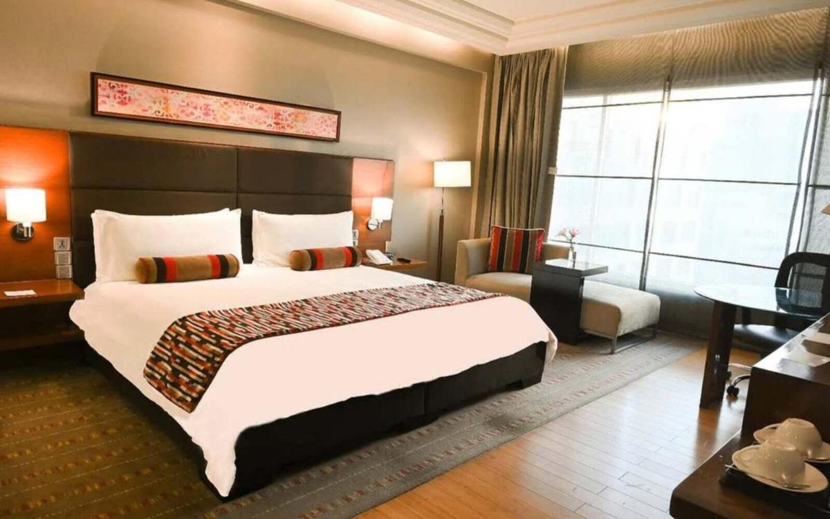 a hotel room with a large bed and a large window at Crowne Plaza Today Gurugram by IHG in Gurgaon