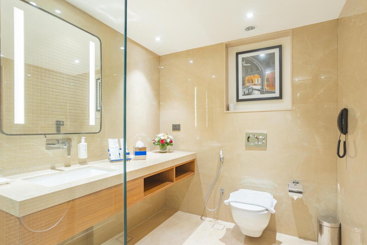 a bathroom with a toilet and a sink at Golden Tulip Jaipur in Jaipur