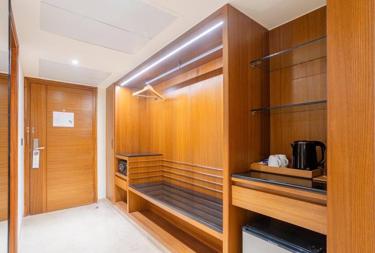 a walk in closet with wood paneling and a door at Golden Tulip Jaipur in Jaipur