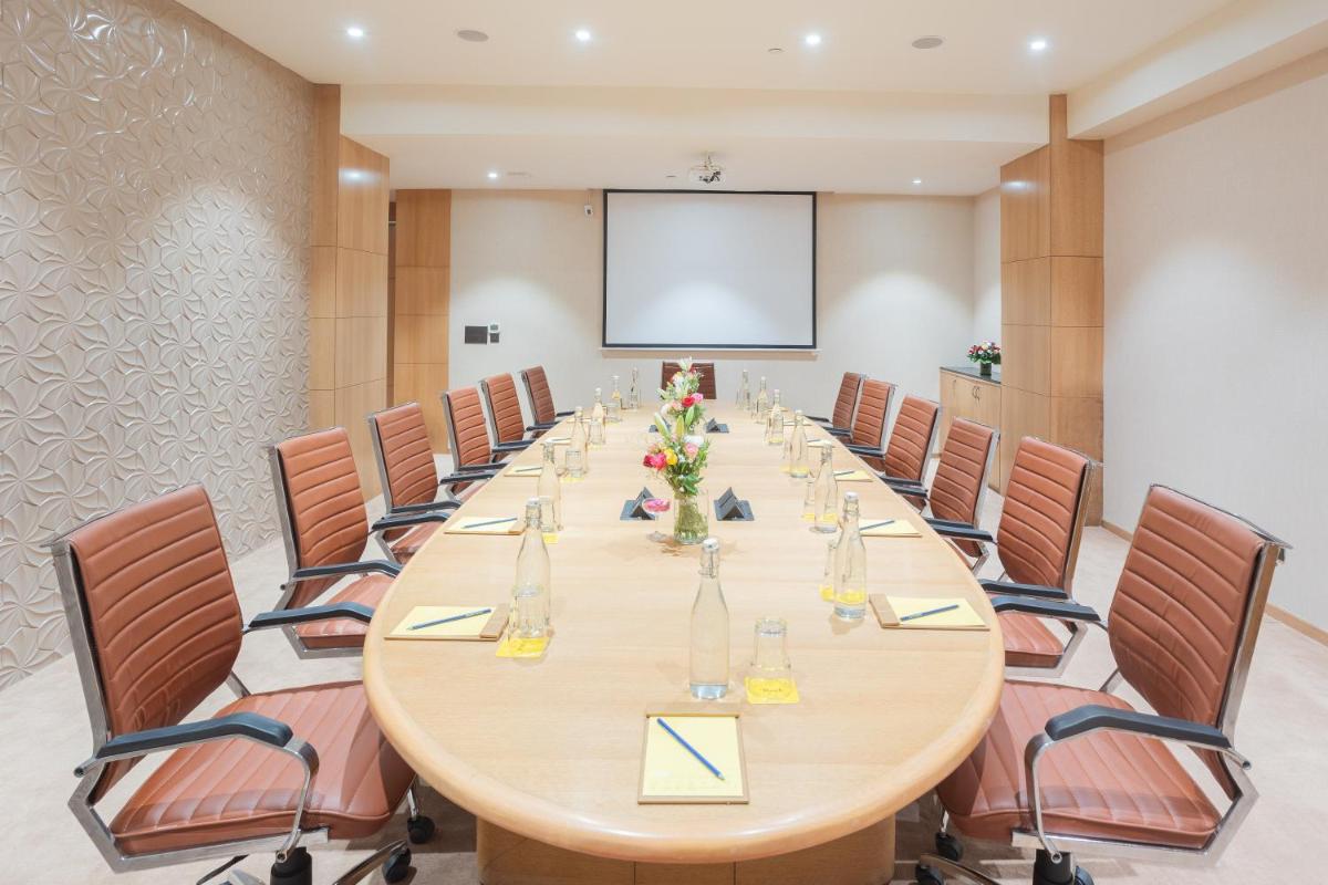 a large conference room with a long table and chairs at Golden Tulip Jaipur in Jaipur
