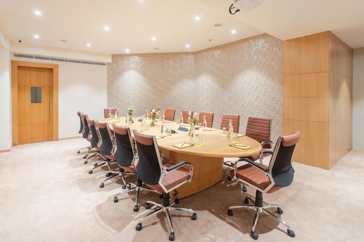 a conference room with a long table and chairs at Golden Tulip Jaipur in Jaipur