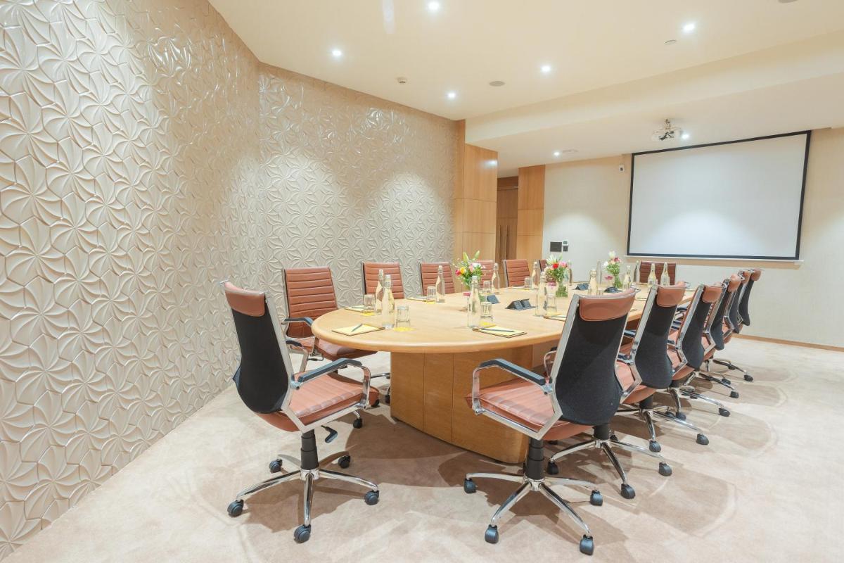 a conference room with a long table and chairs at Golden Tulip Jaipur in Jaipur