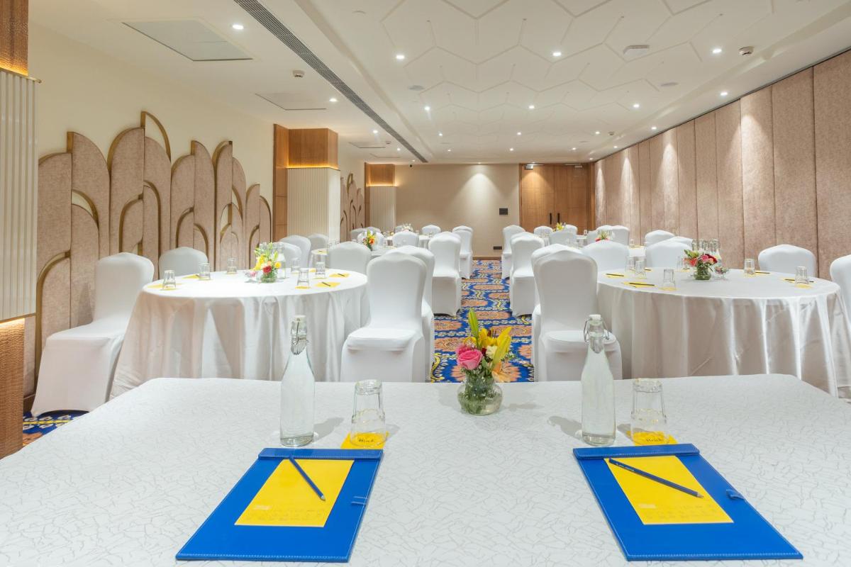 a conference room with white tables and white chairs at Golden Tulip Jaipur in Jaipur