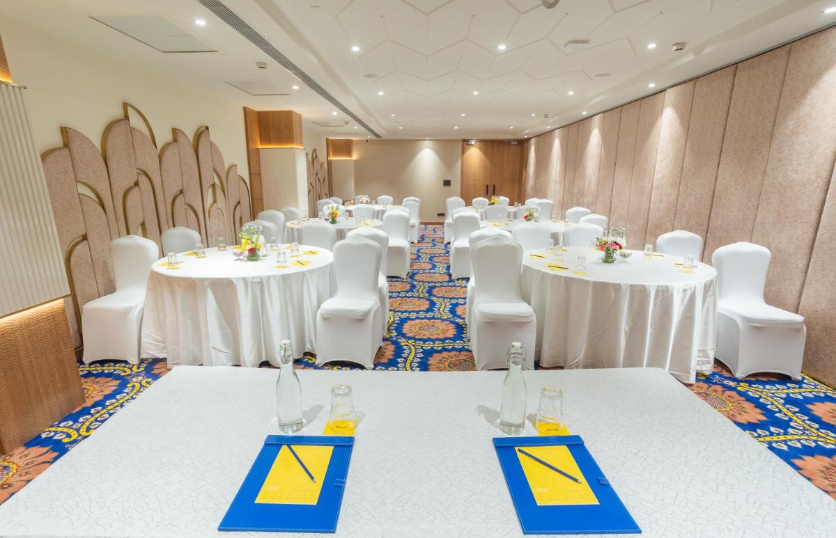a conference room with white tables and white chairs at Golden Tulip Jaipur in Jaipur