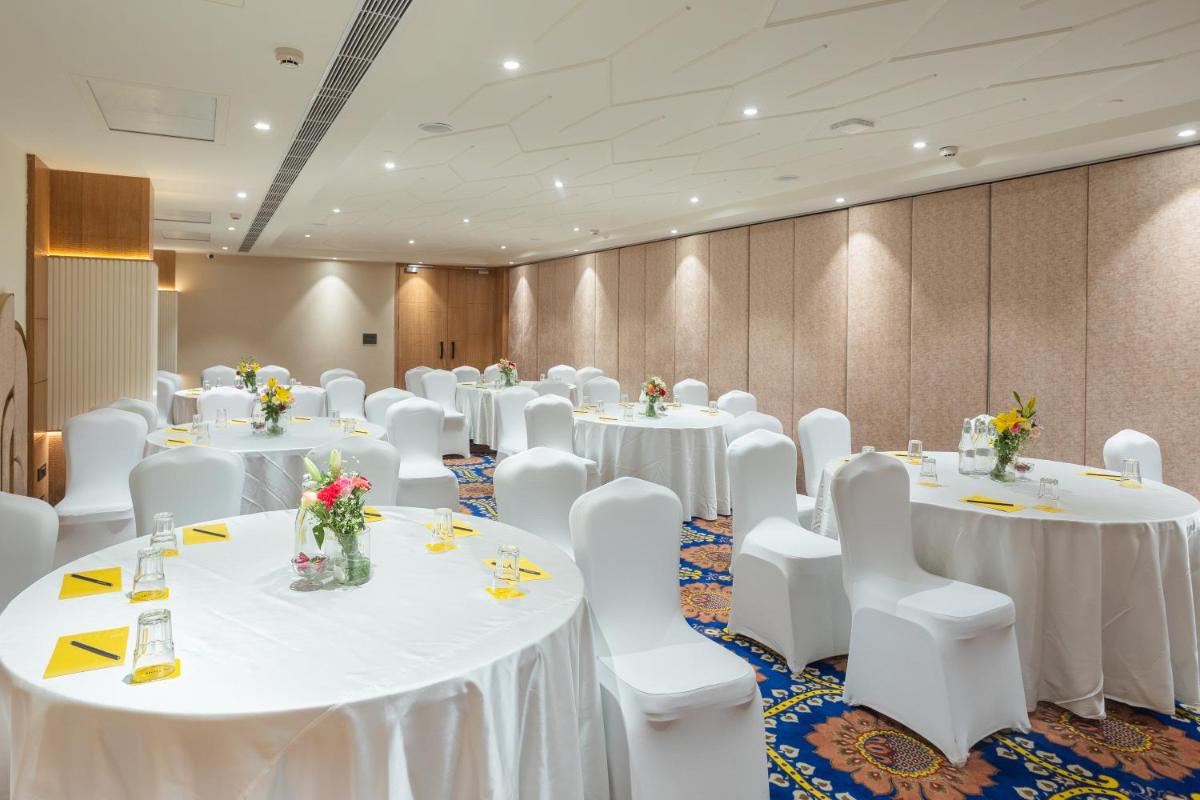 a conference room with white tables and white chairs at Golden Tulip Jaipur in Jaipur