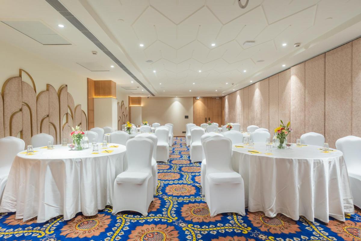 a conference room with white tables and white chairs at Golden Tulip Jaipur in Jaipur
