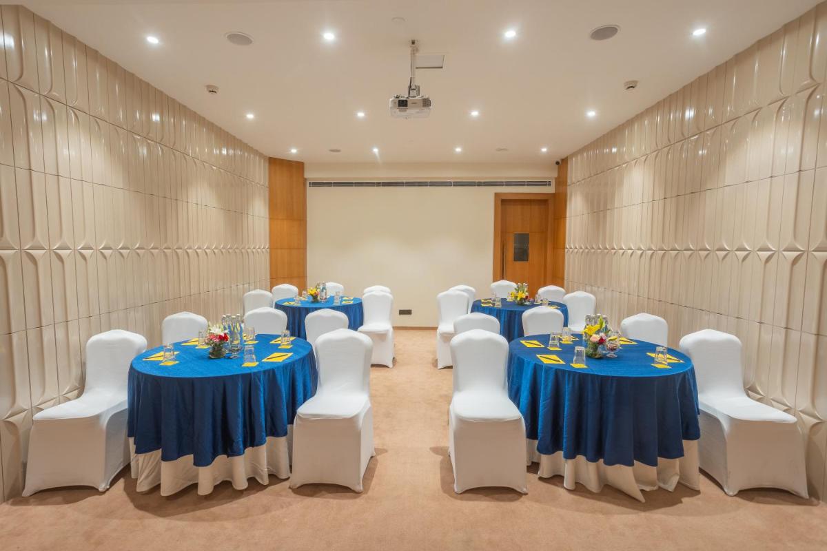 a conference room with blue tables and white chairs at Golden Tulip Jaipur in Jaipur