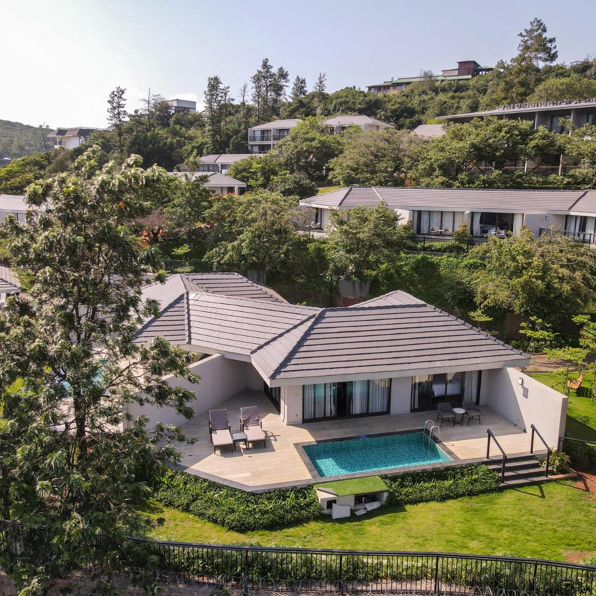 an aerial view of a house with a swimming pool at Courtyard by Marriott Mahabaleshwar in Mahabaleshwar