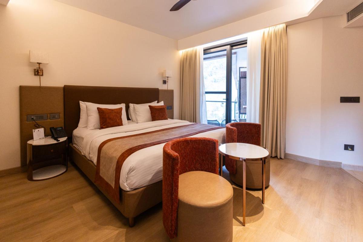 a bedroom with a large bed and a window at Antalya By Divine Ganga Cottage in Rishīkesh