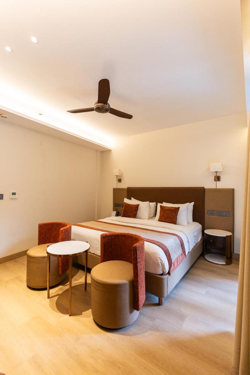 a hotel room with a bed and a table at Antalya By Divine Ganga Cottage in Rishīkesh