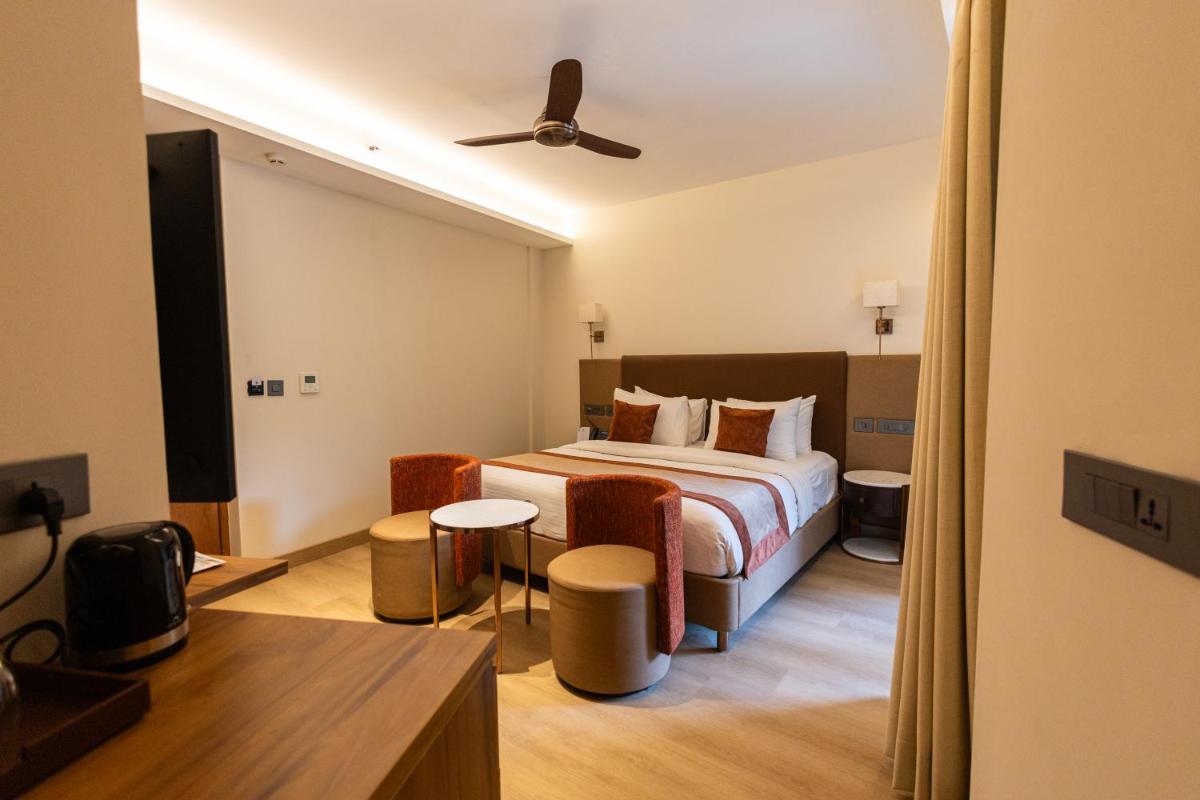 a hotel room with a bed and a tv at Antalya By Divine Ganga Cottage in Rishīkesh