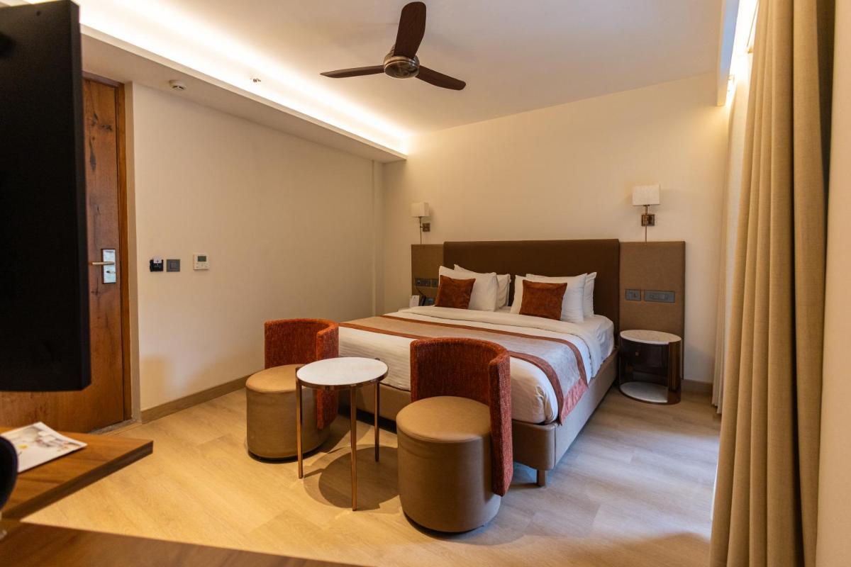 a hotel room with a bed and a tv at Antalya By Divine Ganga Cottage in Rishīkesh