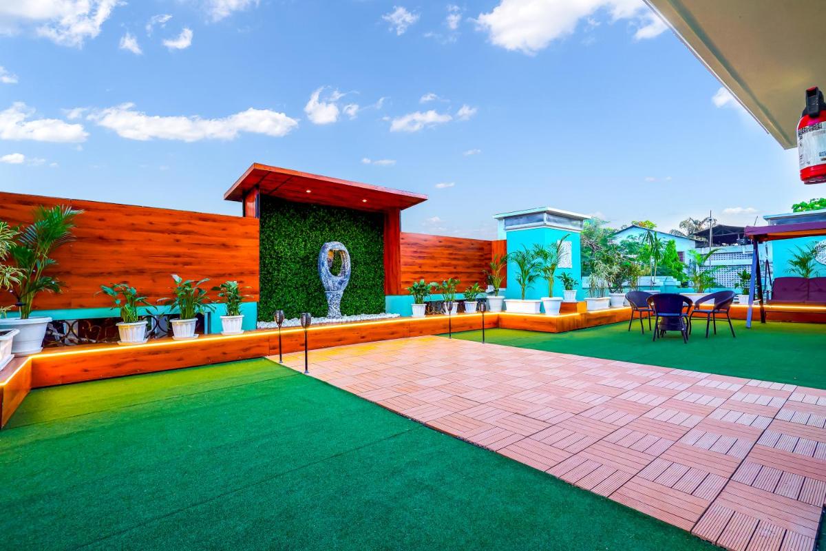 a patio with a green floor and a wooden fence at MyOtel - Santacruz in Mumbai
