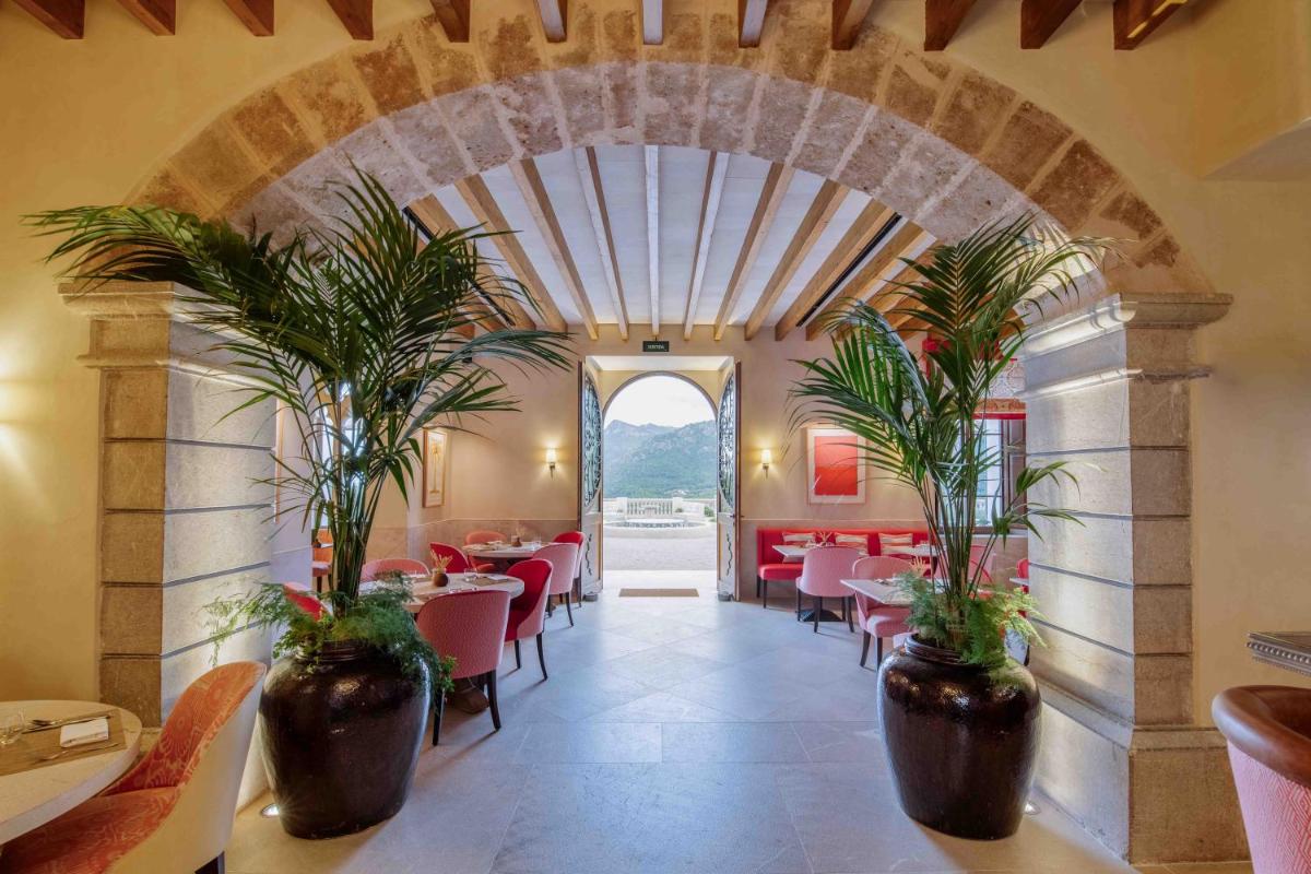 un comedor con mesas y macetas en Son Bunyola Resort and Villas, en Banyalbufar