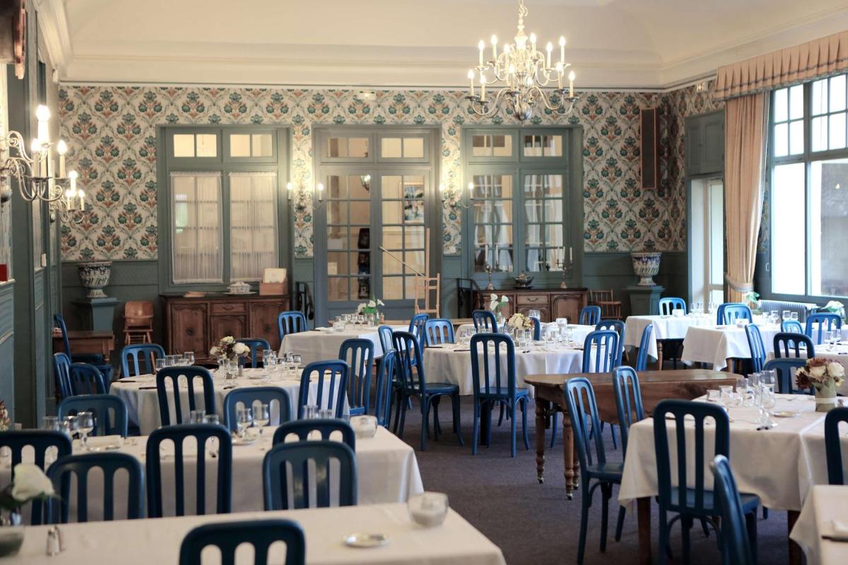 une salle à manger avec des tables blanches et des chaises bleues dans l'établissement Best Western Grand Hotel de Paris & Spa, à Villard-de-Lans