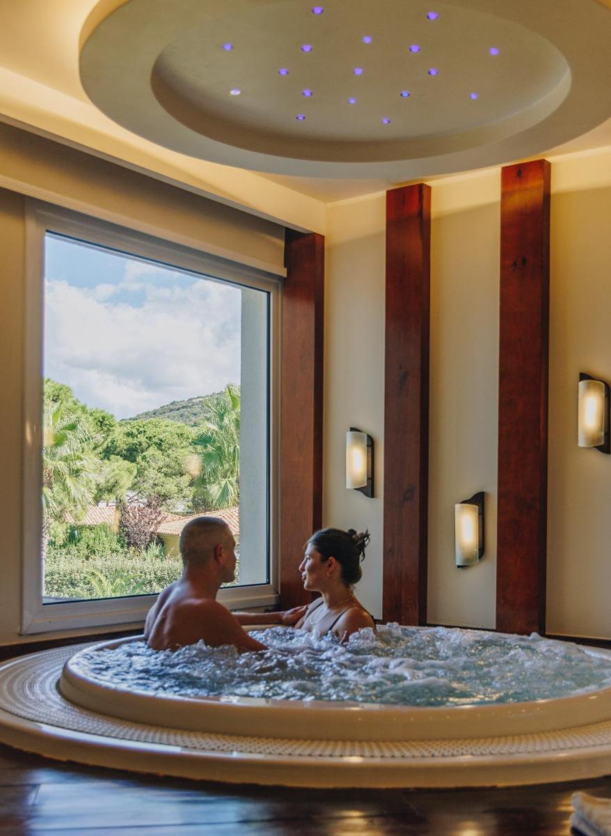 un homme et une femme assis dans une baignoire dans l'établissement Hotel Corsica & Spa Serena, à Calvi 37 autres photos