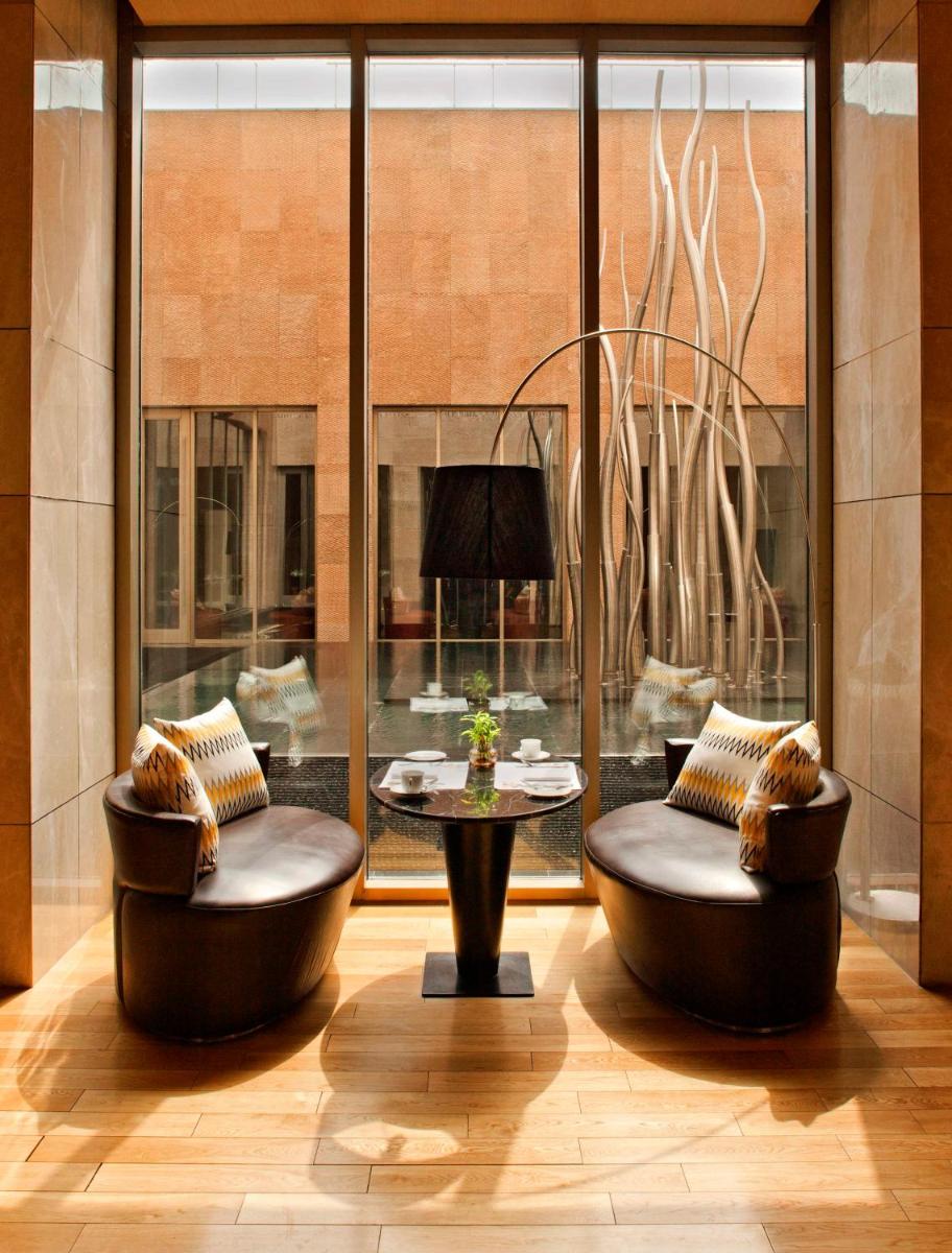 a lobby with two chairs and a table at Radisson Blu Hotel Amritsar in Amritsar