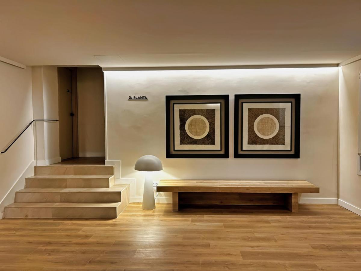 una habitación con un banco y dos pinturas en la pared en Hotel Marina, en Roses